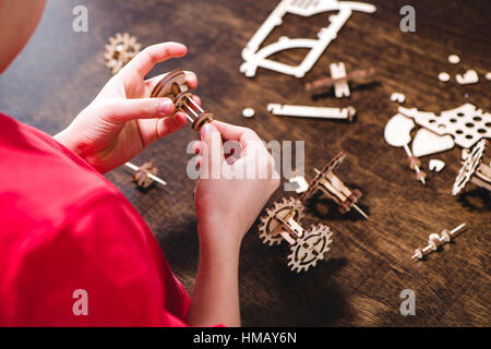 Kid holding wooden gear toy Stock Photo