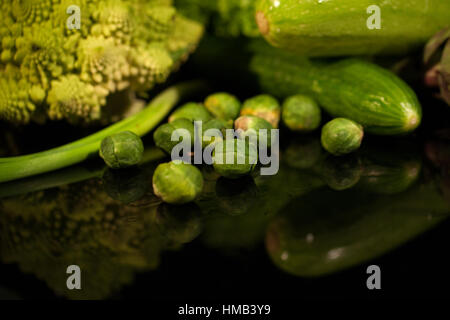 Collection of fresh green vegetables placed on black surface Stock Photo