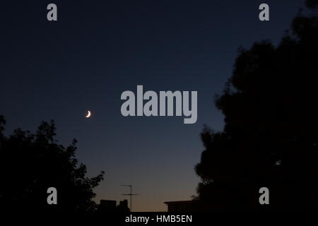 Crimson crescent in a clear night sky Stock Photo