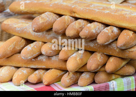 Fresh white baguettes stacked on a market stall in Saint-Palais-sur-Mer, Charente-Maritime, on the southwestern coast of France. Stock Photo