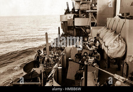 The gun crews of a Navy cruiser covering American landing on the island of Mindoro, Dec. 15, 1944, scan the skies in an effort to identify a plane overhead.  Two 5' (127mm) guns are ready while inboard 20mm anti-craft crews are ready to act.  Navy.  (OWI) NARA FILE #:  080-G-47471 WAR & CONFLICT BOOK #:  1203 Stock Photo