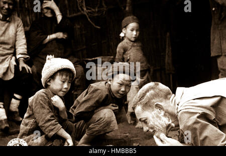 These two Chinese youngsters are fascinated by the sight of an American soldier shaving in the open.  Yunnan, China. June 1944. (Army) Exact Date Shot Unknown NARA FILE #:  111-SC-192535 WAR & CONFLICT BOOK #:  1265 Stock Photo