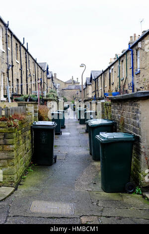 The back alley full of wheelie bins, in the traditional Victorian northern mill town of Saltaire, in Yorkshire, UK Stock Photo