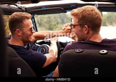 Two Male Friends Driving Open Top Car On Country Road Stock Photo - Alamy