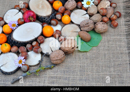 Abstracto con maderas, naranjas, granada, nueces y avellanas Stock Photo