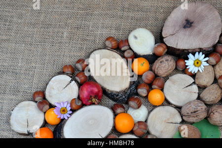 Abstracto con maderas, naranjas, granada, nueces y avellanas Stock Photo