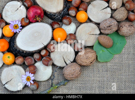 Abstracto con maderas, naranjas, granada, nueces y avellanas Stock Photo