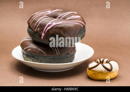 Delicious Donuts in a white plate on dark background Stock Photo