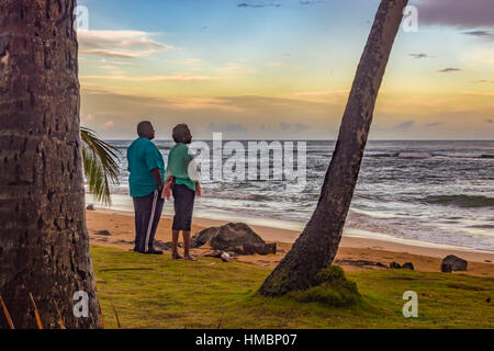 MAN & WOMAN WATCHING THE SUNSET AT LUQUILLO, PUERTO RICO - CIRCA DECEMBER 2013. Stock Photo