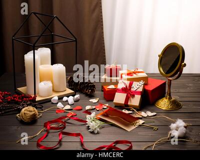 Beautiful valentines day composition with candles, mirror and gift boxes on wooden table Stock Photo