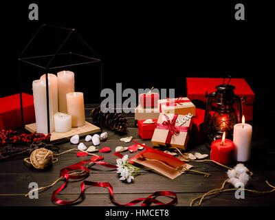 Beautiful valentines day composition with burning candles and gift boxes on wooden table Stock Photo