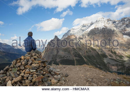 Hiker resting looking up at mountain view, Lake O