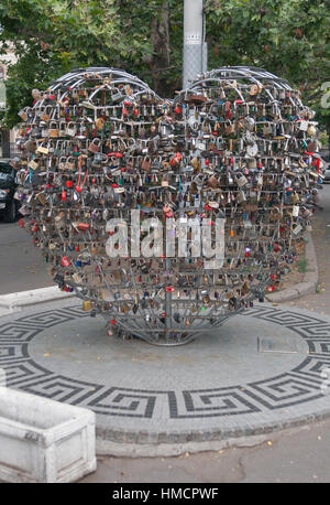 ODESSA, UKRAINE - JULY 16, 2014: Love padlocks hang on the metal structure in the shape of heart. The thousands of locks of loving couples symbolize e Stock Photo