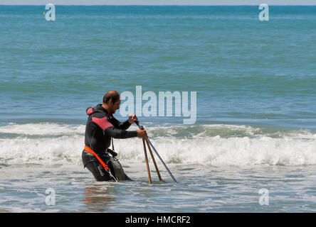 SAN ROSSORE REGIONAL PARK, ITALY - SEPTEMBER 02, 2014: Unrecognizable white middle aged man dressed in a suit for diving with a home-made device catch Stock Photo