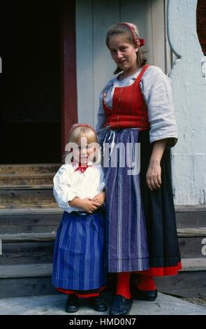 Teenage girl and girl in traditional dress, Skansen open-air museum, Djurgarden, Stockholm, Sweden. Stock Photo
