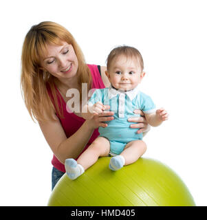 Mother with happy baby doing exercises with gymnastic ball. Concept of caring for children health. Stock Photo