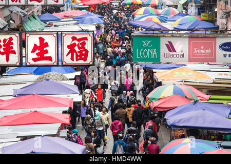 People walk among the shops in the streets in Mong Kok district in Hong Kong Stock Photo