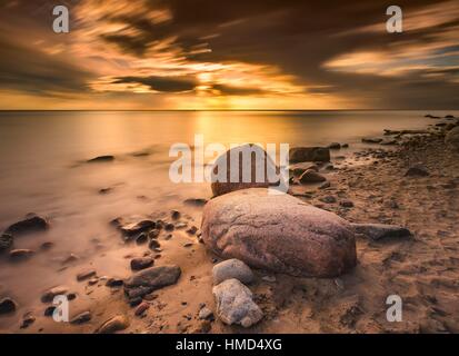 Baltic rocky shore in Gdynia, Poland. Long exposure seascape with shore, rocks and blurred sky and water. Stock Photo