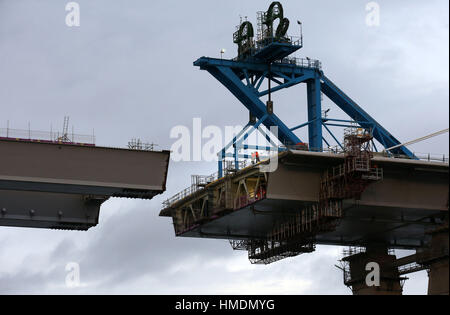 Workmen view the gap as the final deck piece of the Queensferry Crossing sits on a barge ahead of it being lifted into position. Once the operation to start the lift begins, it will take around four hours to complete. Stock Photo