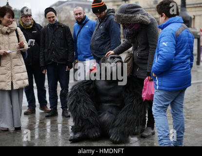 A performer in an animatronic gorilla suit in Trafalgar Square, London, interacts with members of the public during a promotion by the Uganda Tourism Board to highlight Uganda as a holiday destination. Stock Photo