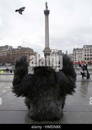 A performer in an animatronic gorilla suit in Trafalgar Square, London, interacts with members of the public during a promotion by the Uganda Tourism Board to highlight Uganda as a holiday destination. Stock Photo