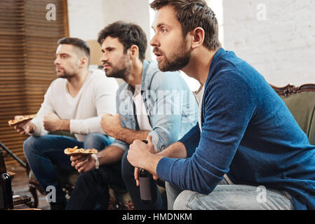 Serious concentrated men watching a football match Stock Photo