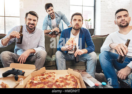 Serious concentrated man holding a slice of pizza Stock Photo