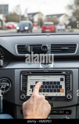 A car driver is using the cars navigation system,  while driving the car, Stock Photo