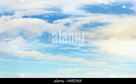 Blue sky with white clouds layered at day with rays of sun Stock Photo