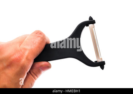 Hand holding black Ceramic peeler for fruits and vegetables isolated on white background. Kitchen utensil, cutlery and accessories. Stock Photo