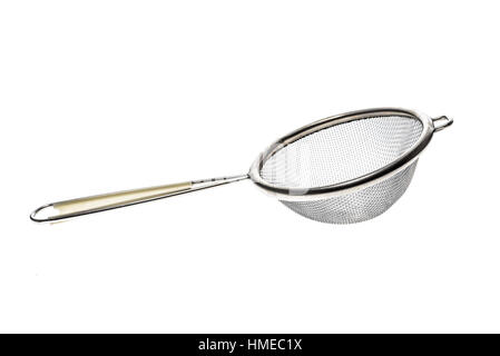 Small metallic tea strainer sieve with handle isolated on white. Modern kitchen utensil for tea or soup filtration. Stock Photo