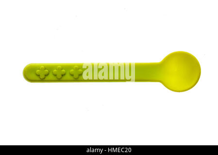 Close-up of a plastic tableware spoon for babies and children. Piece of green plastic cutlery for infants, isolated on white background. Stock Photo