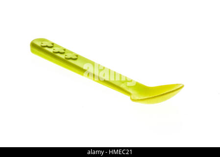 Close-up of a plastic tableware spoon for babies and children. Piece of green plastic cutlery for infants, isolated on white background. Stock Photo