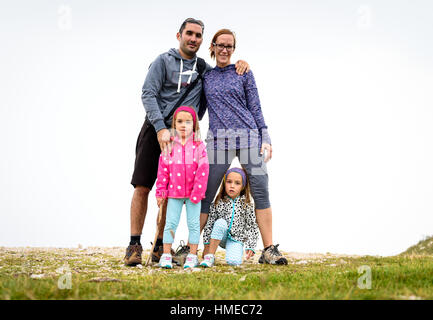 Portrait photo of a family hiking in the mountains, Active family, parents and children mountaineering in the nature. Stock Photo
