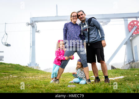 Portrait photo of a family hiking in the mountains, Active family, parents and children mountaineering in the nature. Stock Photo