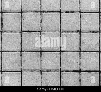 Concrete or cobble gray pavement slabs or stones  for floor, wall or path. Traditional fence, court, backyard or road paving. Dimension 10 x 10 cm Stock Photo