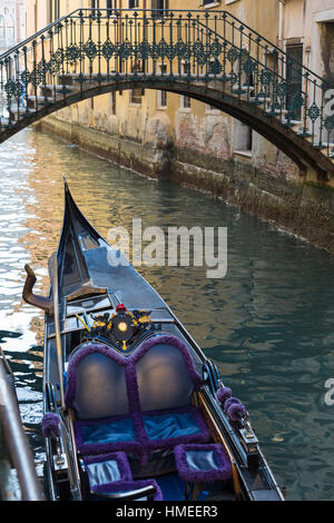 typical Venetian scene with gondola and ornate bridge on side canal at Venice, Italy in January Stock Photo