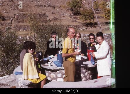 Western tourists eating lunch at an outdoor rest stop in the mountains outside of Kabul, Afghanistan. November, 1973. Stock Photo