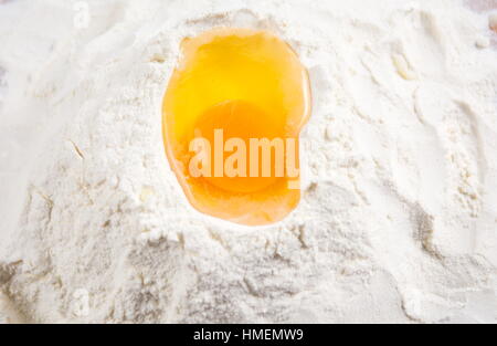 Broken chicken egg on a flour pile Stock Photo