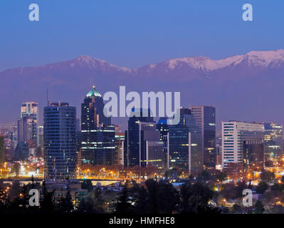 Twilight view from the Parque Metropolitano towards the high rise buildings, and snow covered mountains behind, Santiago, Chile Stock Photo
