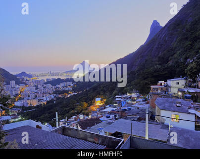 Twilight view of the Favela Santa Marta with Corcovado and the Christ statue behind, Rio de Janeiro, Brazil, South America Stock Photo