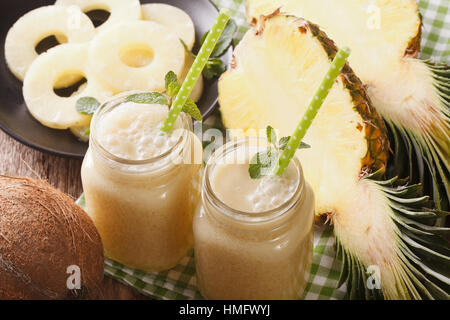 Cocktail of pineapple and coconut in glass jar closeup on the table. Horizontal Stock Photo