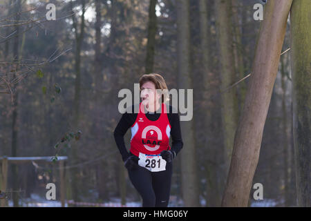 OLDENZAAL, NETHERLANDS - JANUARY 22, 2017: Unknown female athlete doing a cross run in a forest Stock Photo