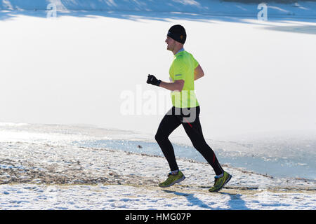 OLDENZAAL, NETHERLANDS - JANUARY 22, 2017: Unknown runner doing a cross run in a snow white landscape Stock Photo