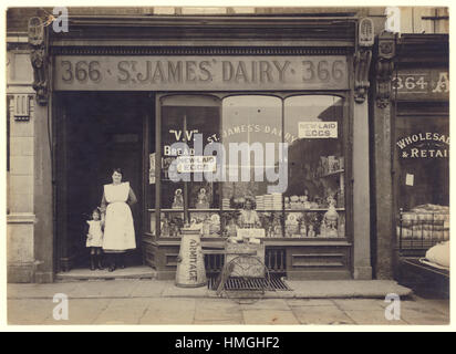 Original early 1900's WW1 era postcard of St. James' Dairy shop / grocery store with female proprietor / owner or staff / assistant and her child, wonderful selection of brands such as Nevill's bread, Tate cube sugar, Armitage, Lyons cocoa and tea. New laid eggs sold loose. London, U.K. circa 1915
