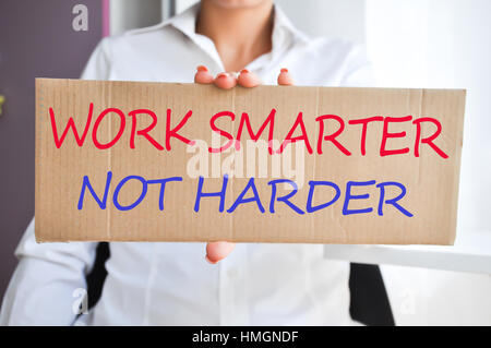 Business woman holding a banner with “Work smarter not harder” Stock Photo