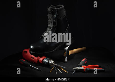 work shoe on black background stay on drill and hammer Stock Photo