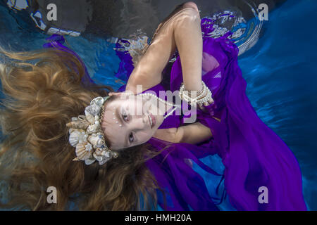 January 29, 2017 - Odessa, Ukraine - ''Play fashion junior'', girl in long, lilac dresses wearing poses underwater, Odessa, Ukraine (Credit Image: © Andrey Nekrasov/ZUMA Wire/ZUMAPRESS.com) Stock Photo