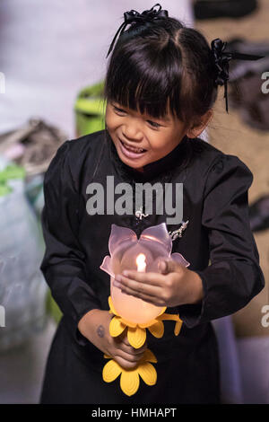 Young girl with candle mourning for late King Bhumibol Adulyadej at Sanam Luang, Grand Palace, Bangkok, Thailand Stock Photo