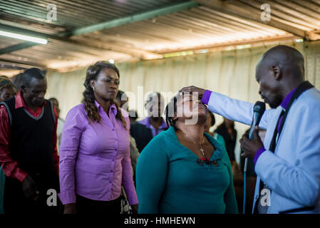 Pastor Chibwe Katebe exorcises the evil spirit from the body of a woman during a Sunday service at the House of Prayer for All Nations in Livingstone, Zambia Stock Photo